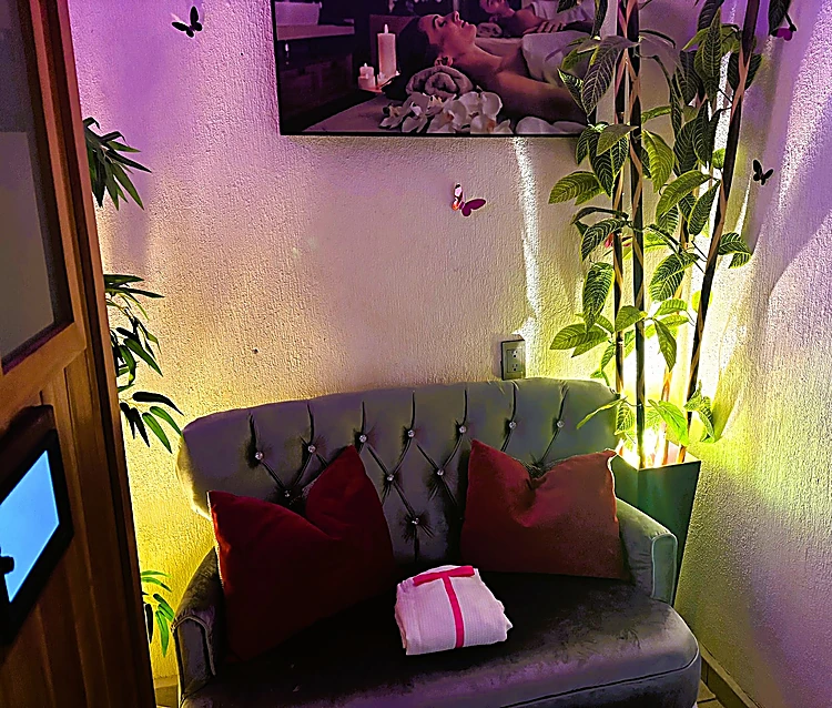 Salón con luz morada, sillón y plantas